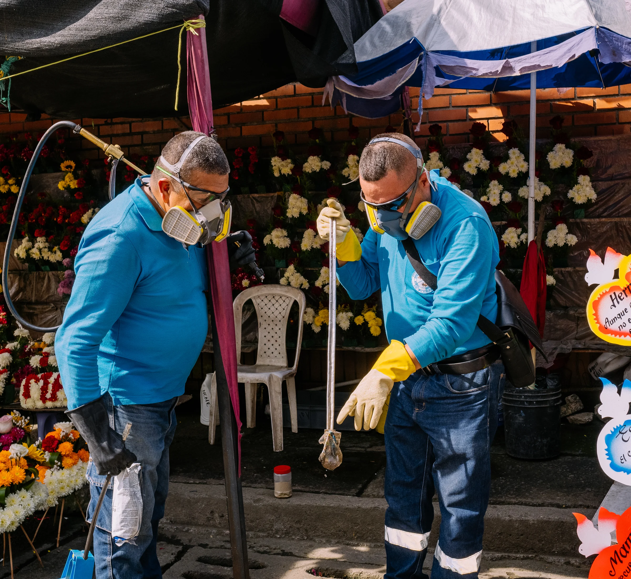 Dos tecnicos de control de plagas trabajando en una alcantarilla