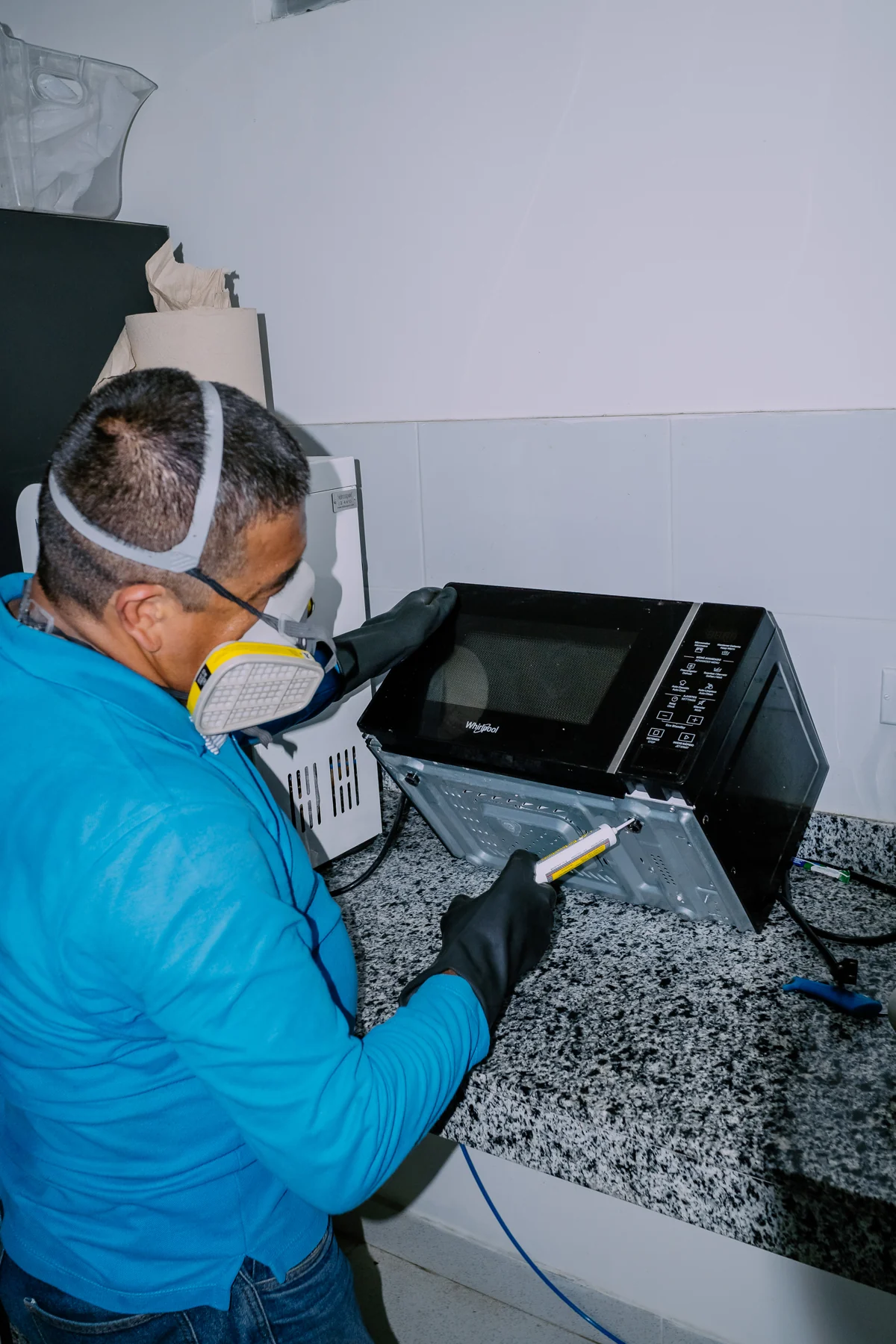 Tecnico de control de plagas aplicando gel cucarachicida