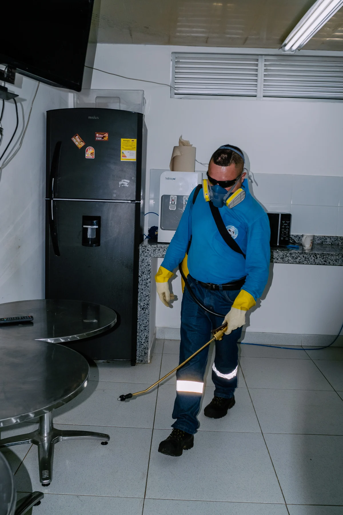 Tecnico de control de plagas fumigando una oficina